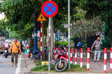 Rào chắn vỉa hè quanh tòa nhà ngăn hàng rong, hàng rong vẫn bán, người đi bộ phải xuống lòng đường